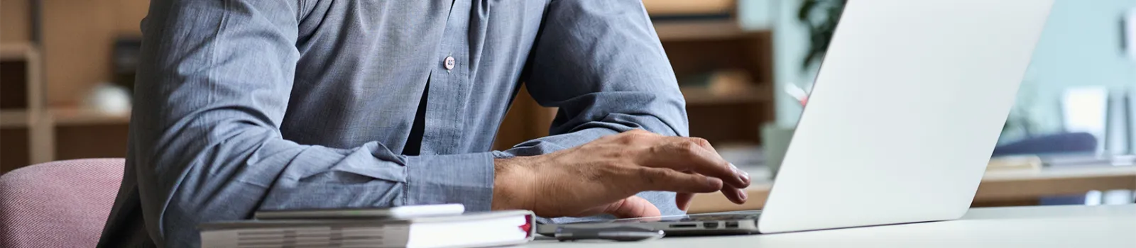 Gentleman's fingers tapping on a laptop touch pad